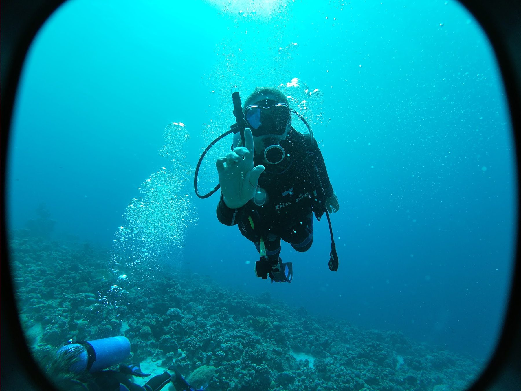 Scuba diver descending through blue water